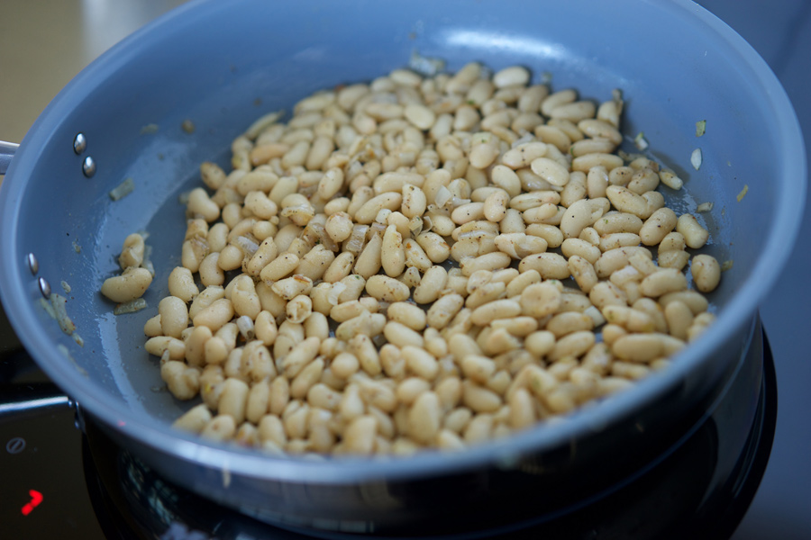 White kidney (Canellini) beans are cooked in a skillet with olive oil and shallots.