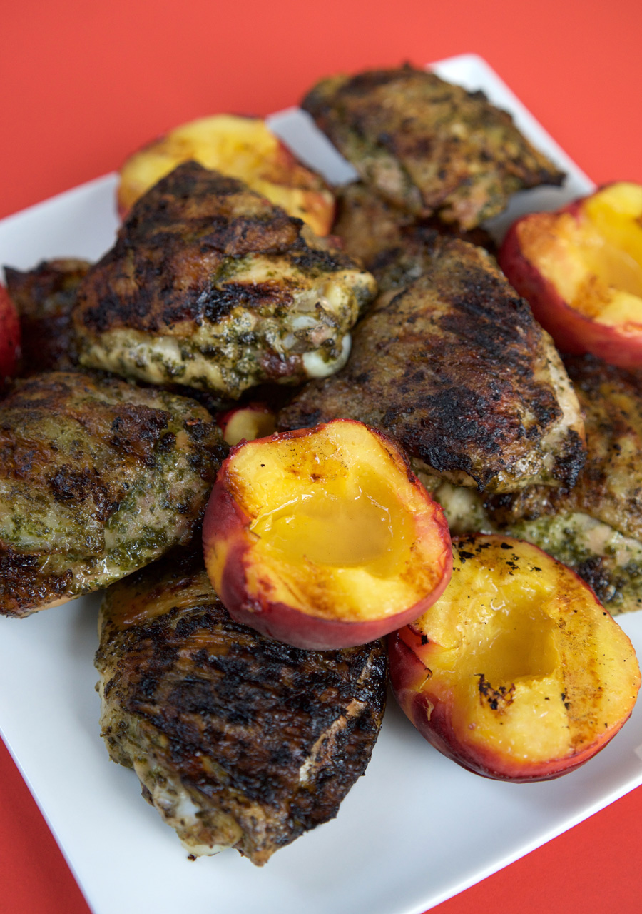 Grilled pesto chicken with peaches piled onto a plate