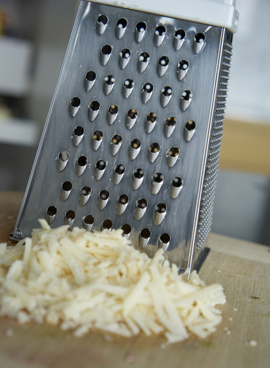 Parmigiano reggiano in front of a metal grater