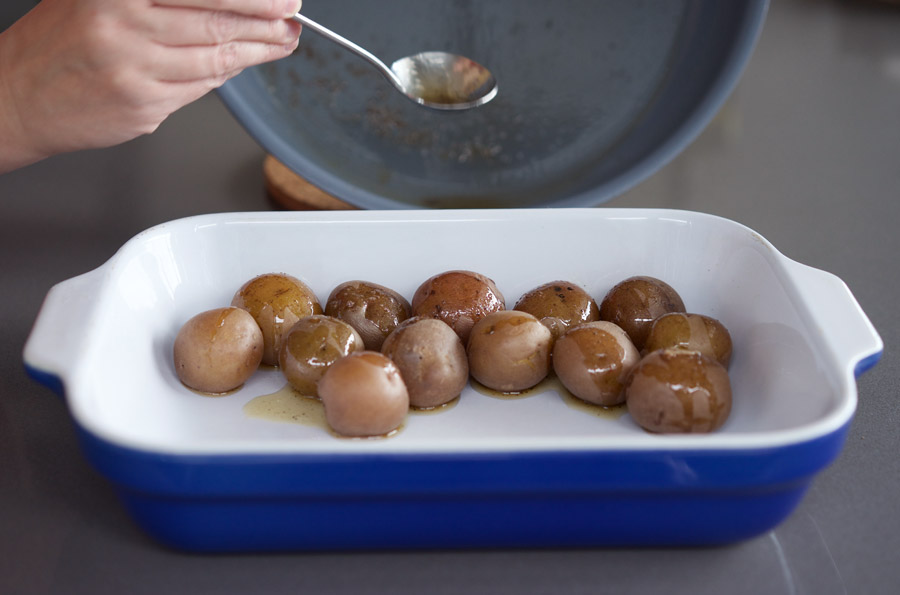 spoon pan juices over baby potatoes