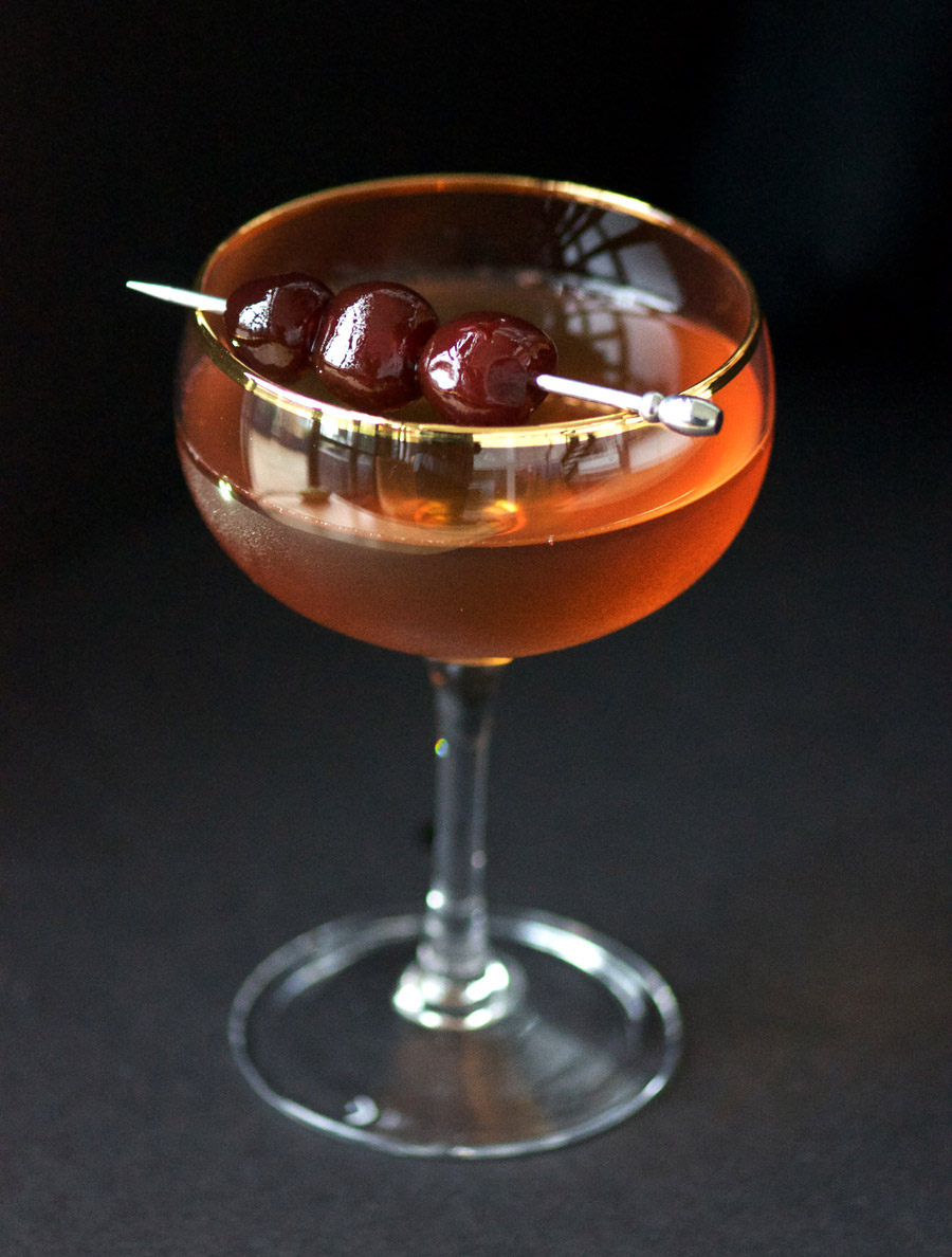 Manhattan with cherries in cocktail glass