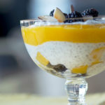 Healthy chia pudding is layered with mango puree and blackberries