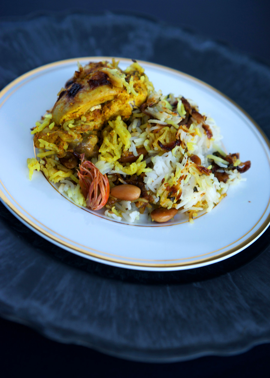 Hyderabadi Biryani showing chicken, colourful rice, mace and spices